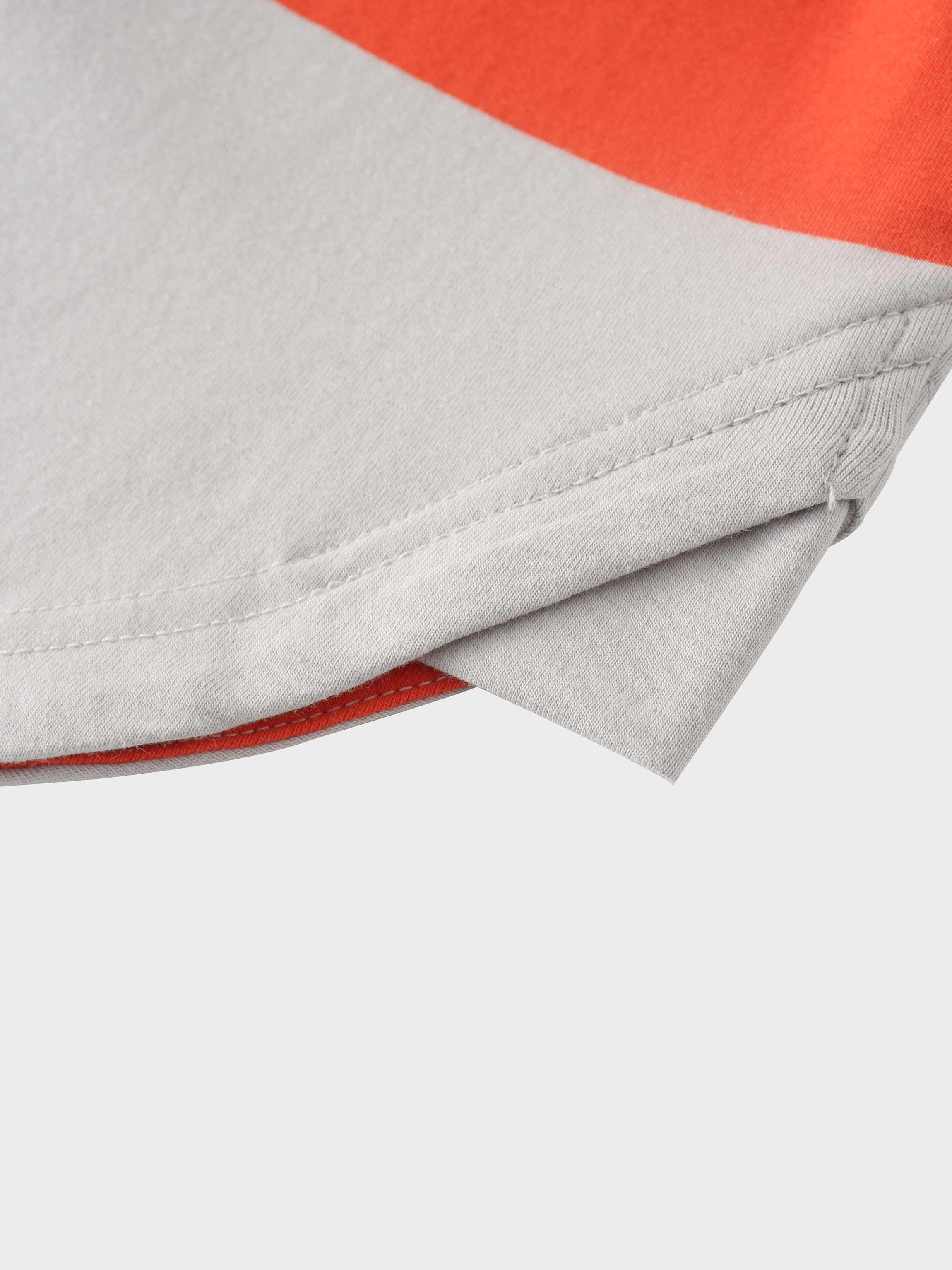 Folded edge of orange and light grey fabric.