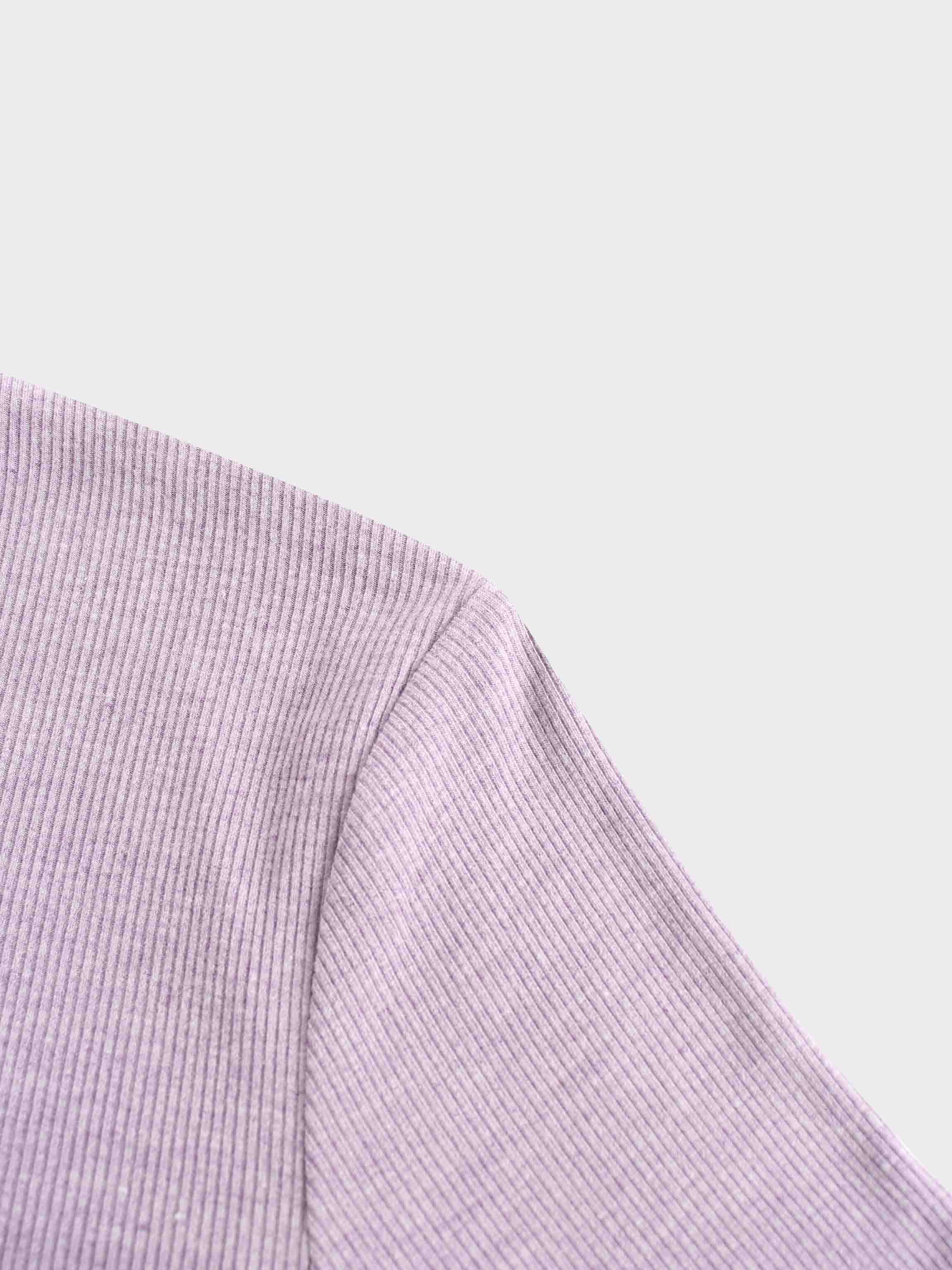 A close-up photo of the shoulder of the lavender-colored top. The image shows the seam where the sleeve is attached to the body of the ribbed garment.