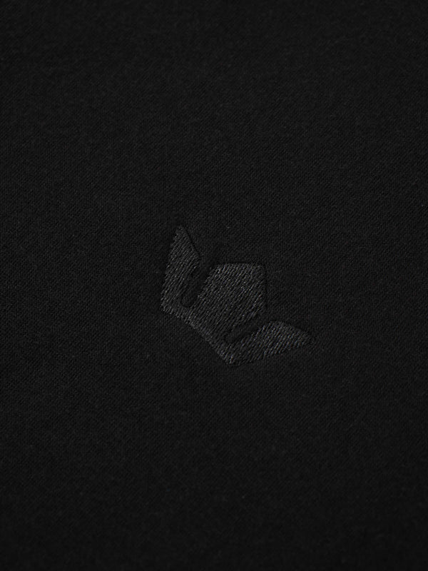A full, front view of the black sweatshirt. The image shows the ribbed collar, cuffs, and hem, along with the subtle, black-on-black embroidered logo on the chest and a white tag inside the neckline.