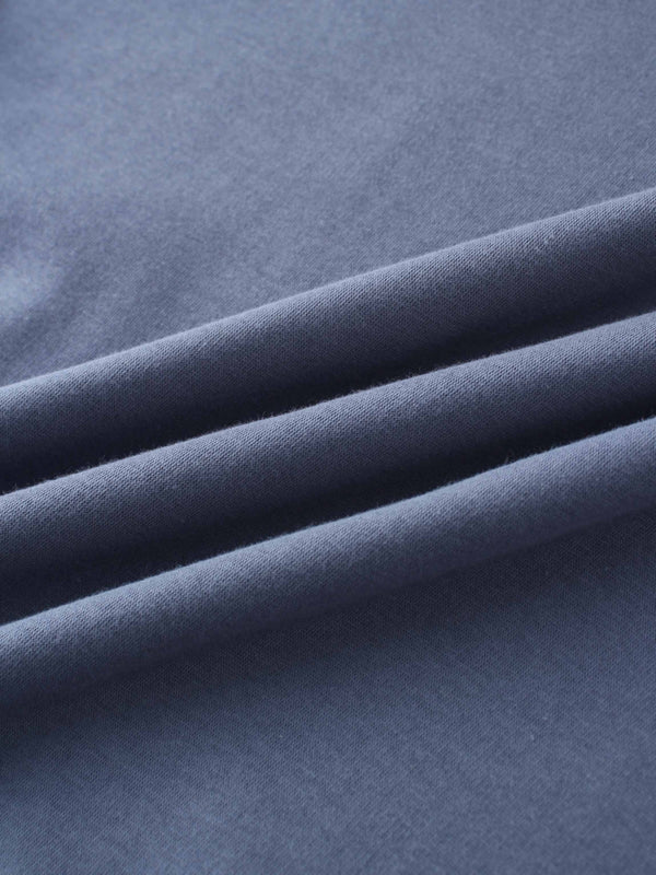 A full, front view of the dusty-blue sweatshirt. It has a ribbed crewneck collar, cuffs, and bottom hem, with the small, tone-on-tone embroidered logo visible on the left chest.
