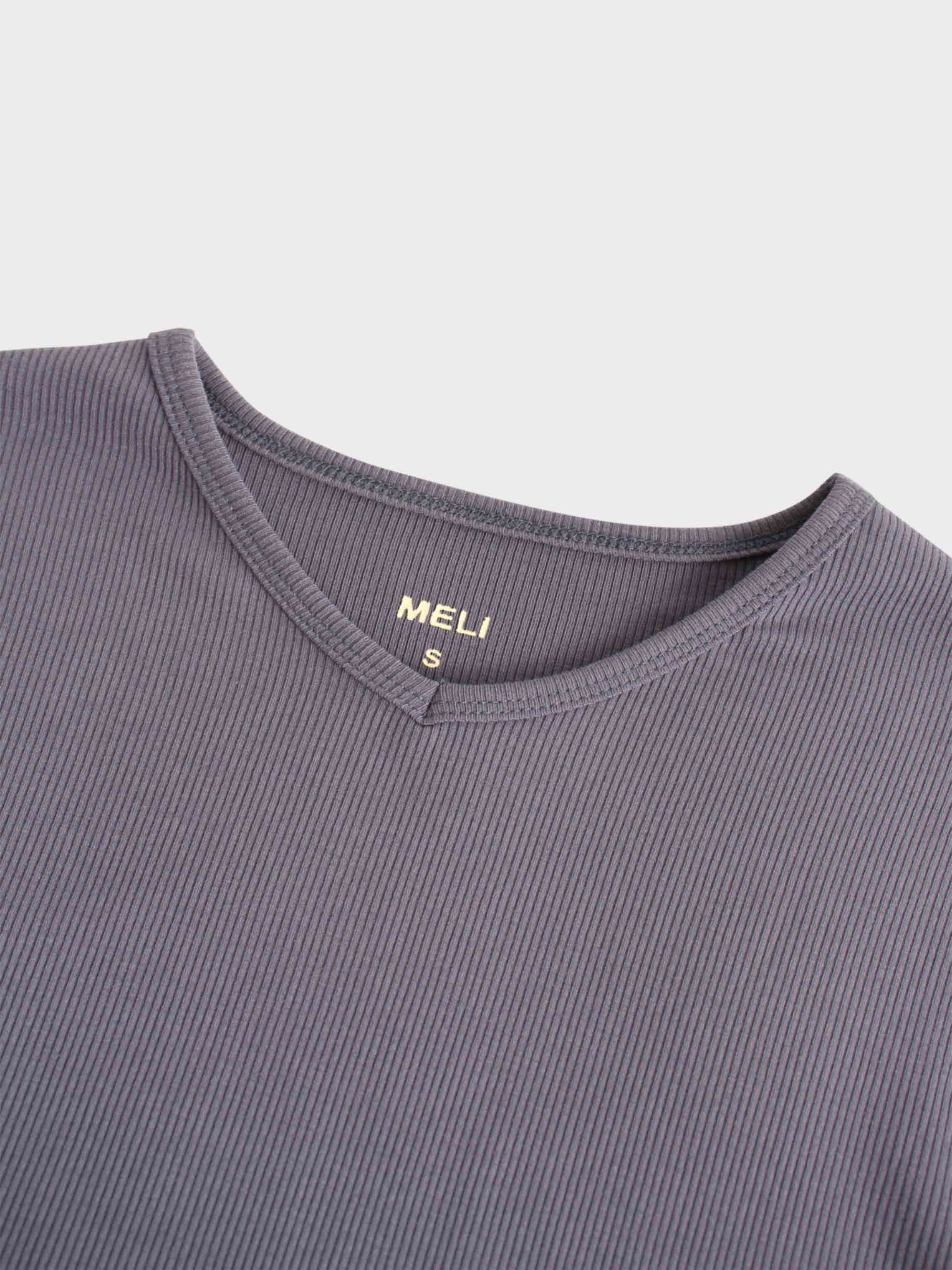 A view of the neckline of the ribbed, purple shirt. It has a small V-shaped notch at the front, and a tag printed in gold on the inside reads &quot;MELI&quot; with an &quot;S&quot; for the size.