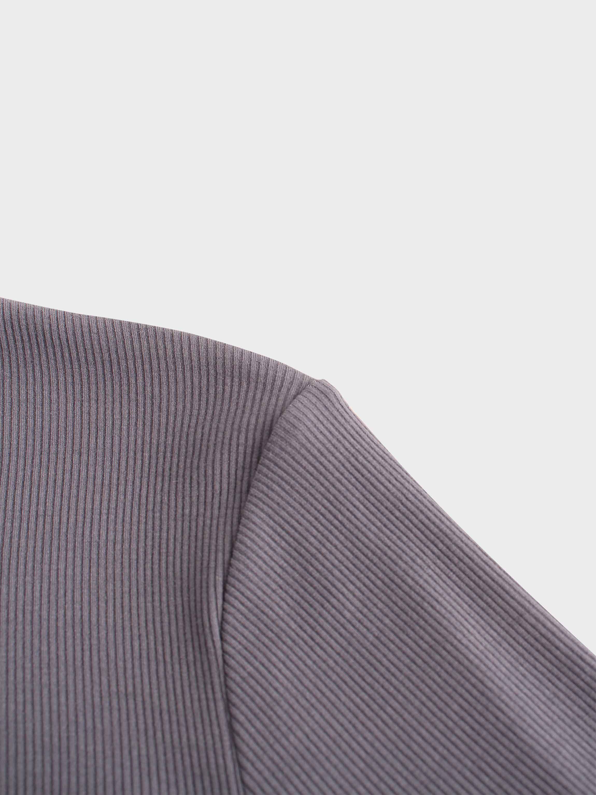 A close-up shot of the shoulder area of the ribbed garment. The image focuses on the seam where the sleeve is attached to the body of the shirt.