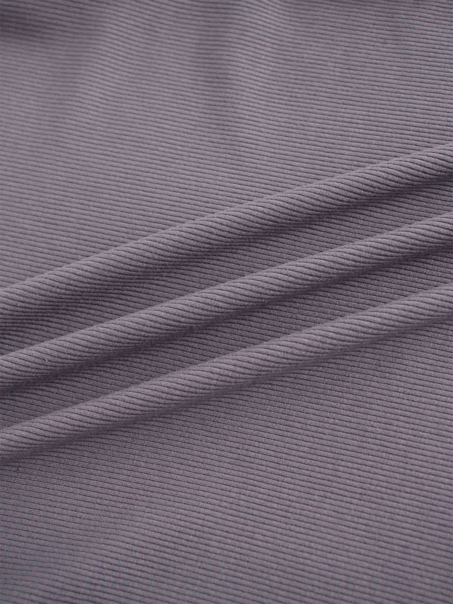 A soft, flexible material with a ribbed pattern, shown here in a muted shade of purple. The fabric is gathered, creating diagonal shadows.